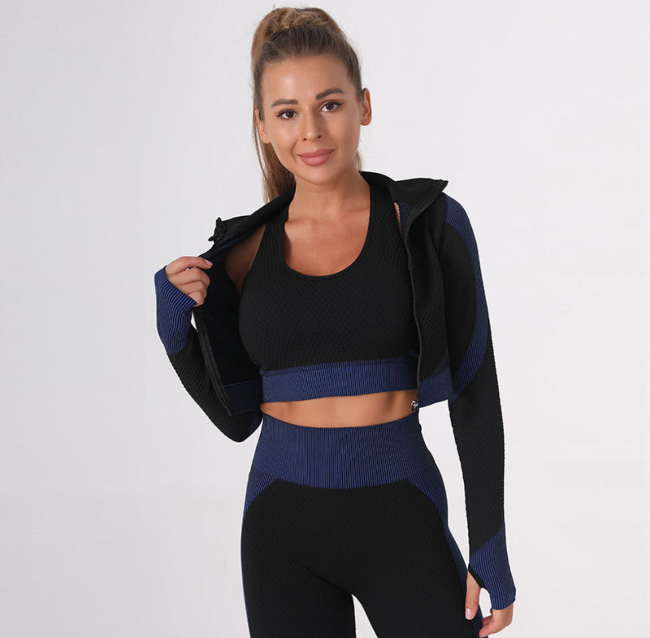 A three-piece athletic set consisting of a sports bra, leggings, and a zip-up jacket.